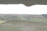 View from makeshift window in abandoned building on sheep pasture