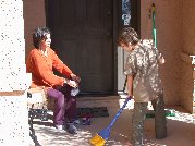 Rom sweeps our front porch as Adi gets ready for outdoor excursion