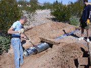Paul clears away more dirt from the downside of the culvert to ensure proper water flow Paul clears away more dirt from the downside of the culvert to ensure proper water flow