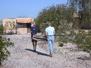 Jack and Paul lug the old pipes to behind the outbuilding for some future use or disposal Jack and Paul lug the old pipes to behind the outbuilding for some future use or disposal