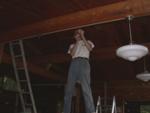 Paul uses the piano top to reach the ceiling wiring for lights