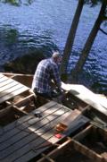 Sawing off excess board under steps, partly rotted from collected leaves/needles