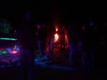One of decoratively torch-cut fire barrels nearly obscured by those getting warm One of decoratively torch-cut fire barrels nearly obscured by those getting warm