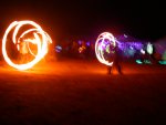 Fire dancers with black lighted area beyond