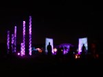 View of light towers from behind camp fire